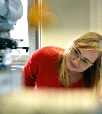 Eine Studentin untersucht ein technisches Gerät in einem Workshop
