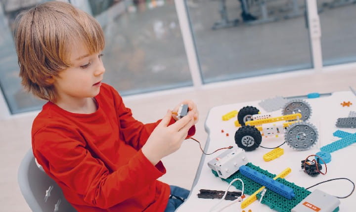 Ein Junge bastelt an einem technischen Projekt mit Lego