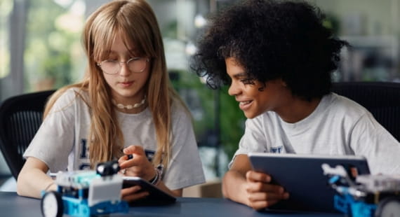Ein Junge und ein Mädchen programmieren Roboter